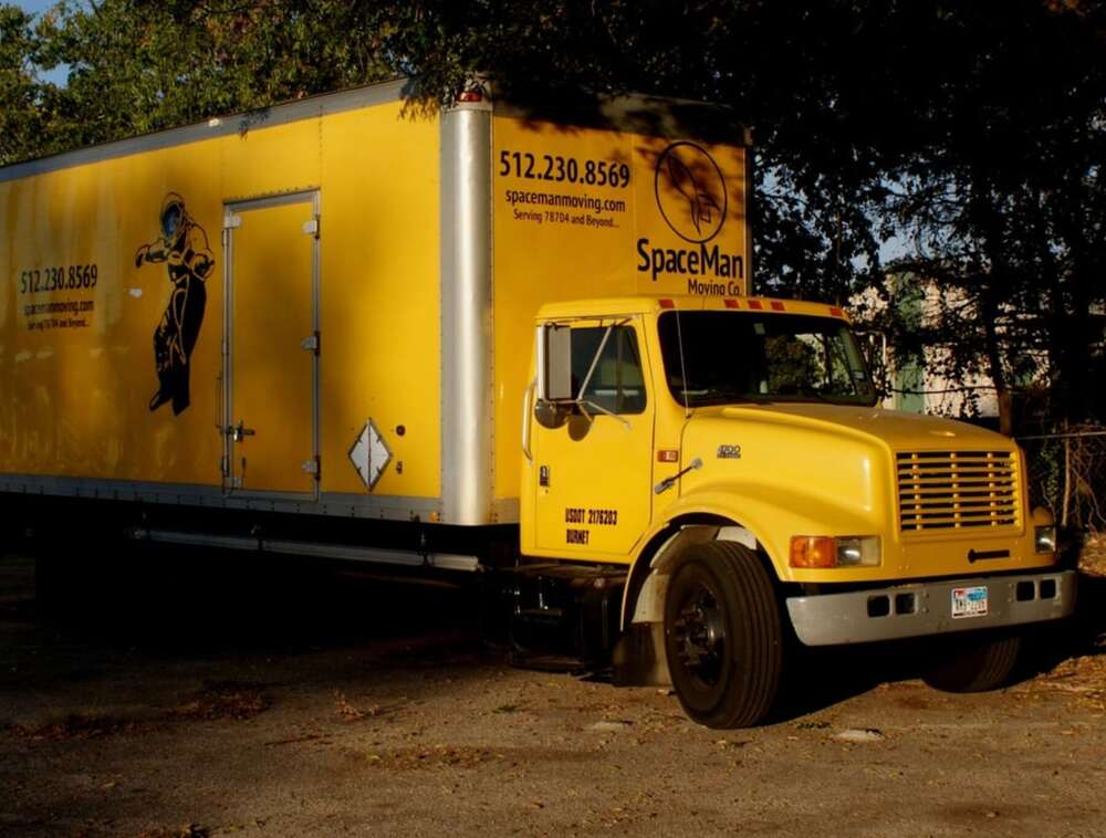 A SpaceMan Moving box truck with the rocket logo, parked in Austin